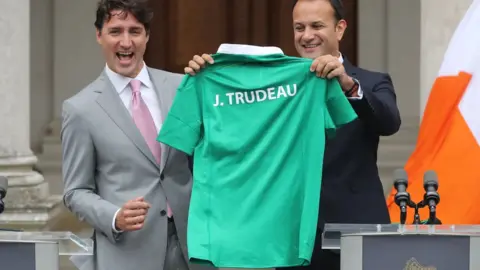 PA/Niall Carson Leo Varadkar presents Justin Trudeau with a personalised Ireland rugby shirt.