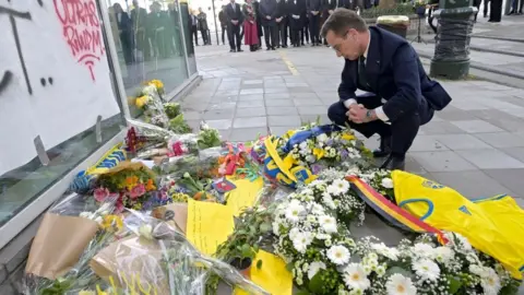 Getty Images Swedish Prime Minister Ulf Kristersson looking at flowers in Brussels laid to commemorate the victims of the attack