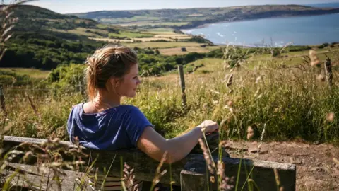 Ceri Oakes Woman sitting on a bench in Ravenscar