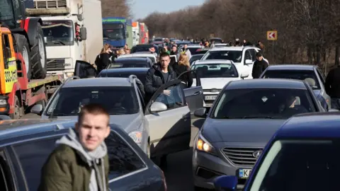 Reuters People wait in a traffic jam as they leave the city of Kharkiv, after Russian President Vladimir Putin authorised a military operation in eastern Ukraine