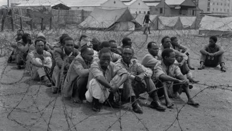 Getty Images Suspected Mau Mau fighters being held in a camp