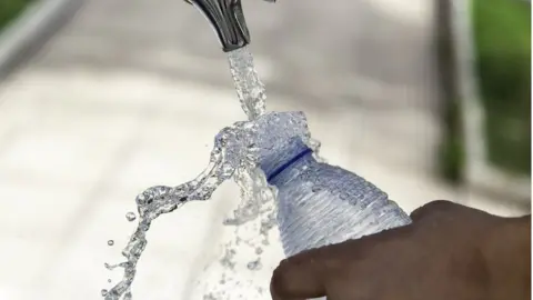 Getty Images a person filling a bottle of water