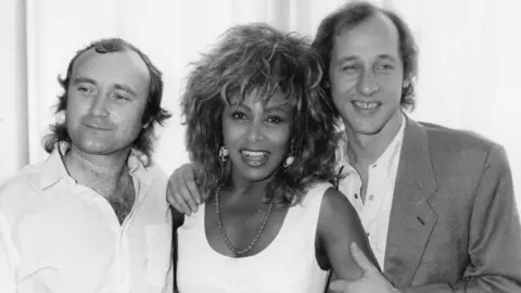 Getty Images Musicians (L-R) Phil Collins, Tina Turner and Mark Knopfler at an event to honor Princess Michael of Kent, England, July 8th 1986