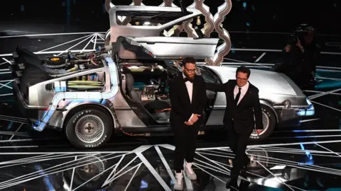 MARK RALSTON/Getty Seth Rogan and Michael J Fox with a DeLorean