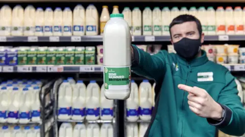 MOrrisons Store worker holding milk