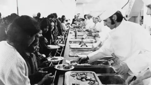 Ugandan Asian refugees being served meals at Stradishall reception centre, near Newmarket, in Suffolk, October 1972.