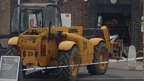 Dave Wright JCB near damaged shop