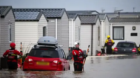 Getty Images Emergency crews at the flooded Freshwater Beach Holiday Park at Burton Bradstock