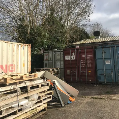 CATS PROTECTION Tree next to shipping containers