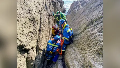 Getting patient onto a stretcher to remove him from the cave