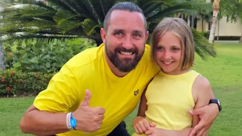 PA Media/Nick Passey Nick Passey holding Caitlin