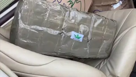 Parcel filled with marijuana sat on beige plane seat