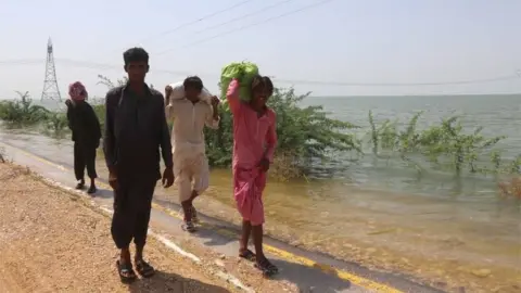 EPA People move to higher grounds after their villages were inundated by flood following a breach in Manchar Lake to reduce overflow, in Jamshoro district, Sindh province, Pakistan, 06 September 2022.