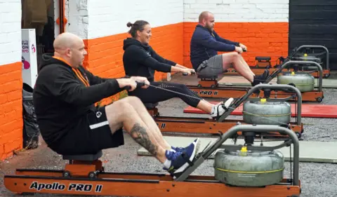 Owen Humphreys People take part in a small exercise class at the Lionheart Fitness gym in Bedlington, Northumberland, which has moved some equipment into the car park as indoor gyms are still not permitted to open due to coronavirus lockdown restrictions.