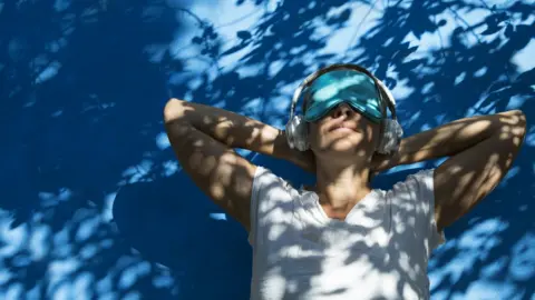 Getty Images woman in eye shade listening to music