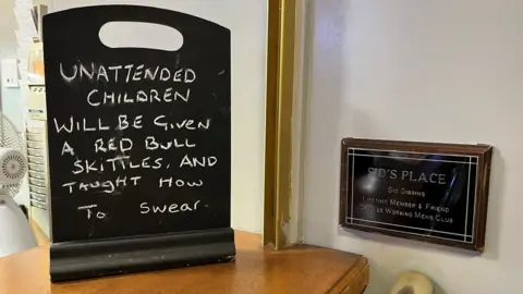 Kevin Shoesmith/BBC A humorous sign on the bar warning unattended children will be "given a Red Bull and Skittles and taught how to swear"