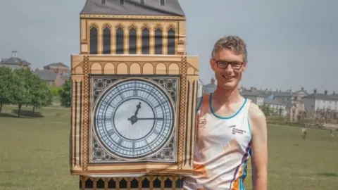 PA Media Simon Phillips in Big Ben costume