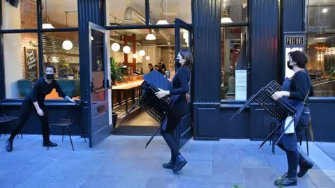 PA Media Staff putting away chairs and tables at a bar