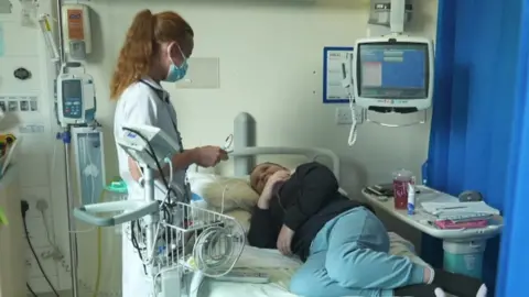 Claudia Laird on hospital ward attending to patient