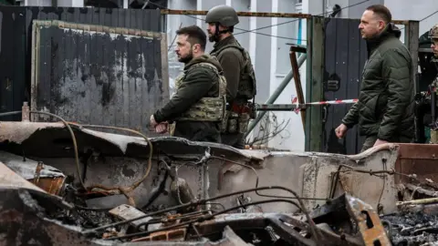 Getty Images Ukrainian President Volodymyr Zelensky (C) visited in the town of Bucha, northwest of the Ukrainian capital Kyiv, earlier this month