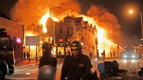 Getty Images Firefighters battle a large fire that broke out in shops and residential properties