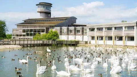 Slimbridge Wetland Centre Slimbridge Wetland Centre with a host of birds in front of it in a pond