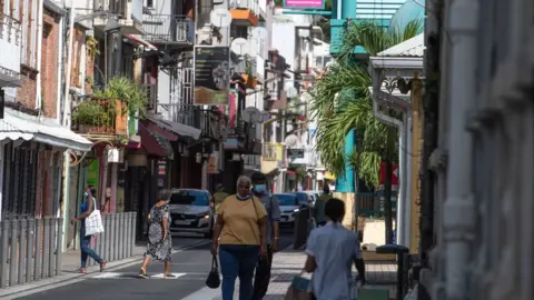 Bystanders stroll in the streets in the city of Fort-de-France, Martinique