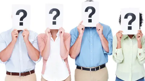 Getty Images People holding question marks over their faces