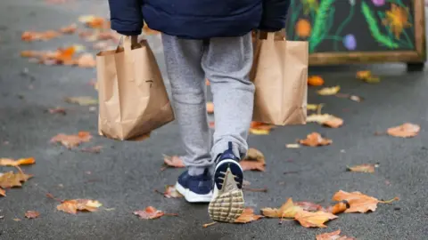 PA Media Boy carrying food bags