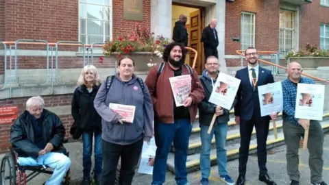 Aled Thomas Group with signs