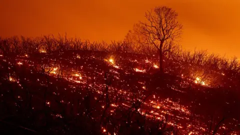 AFP / Getty Images  Embers smoulder along a hillside after the Ranch Fire, part of the Mendocino Complex Fire, in California, on August 5, 2018.