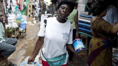 Getty Images Felicity, age 20, walks in the central market selling the Oldenberger milk powder on August 8, 2009 in Bamenda, Cameroon