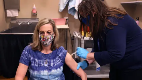 Scott Olson/Getty Images A female United Airlines employee receives a COVID-19 vaccine at United's onsite clinic at O'Hare International Airport on March 09, 2021 in Chicago, Illinois.