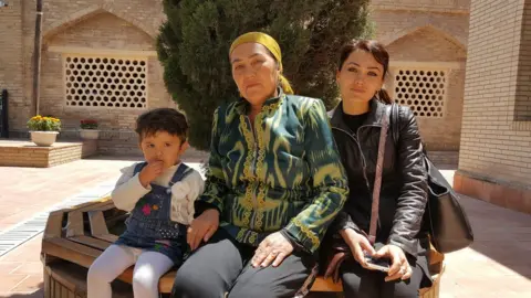 BBC Dilrabo and her daughter and granddaughter relaxing after praying at the Daniyar shrine