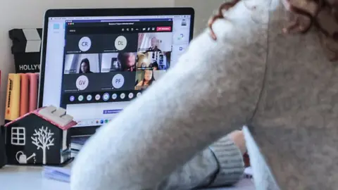 Getty Images A woman speaks to other people on a video call