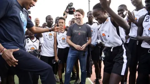 AFP via Getty Images Canadian Prime Minister Justin Trudeau and Toronto Raptors president Massai Ujiri attend a a ceremony between Canada and Senegal Olympic committees