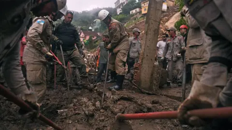 Getty Images Firefighters are seen during a rescue mission after a giant landslide at Caxambu neighborhood in Petropolis