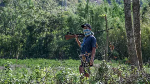 Getty Images An armed Kuki man guards a village in Churachandpur district in the north-eastern state of Manipur