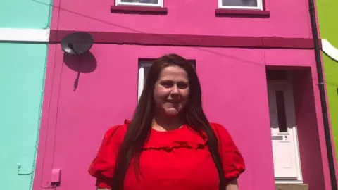 Russhelle Archer outside her pink house