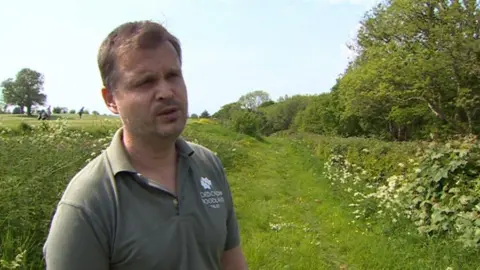 Nigel Pugh, of The Woodland Trust, standing next to an area known as the Long Wood, which reaches across the Vale close to where the new road would be built