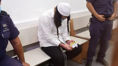 EPA Amiram Ben Uliel bows his head during his trial for murder at Lod District Court (18 May 2020)