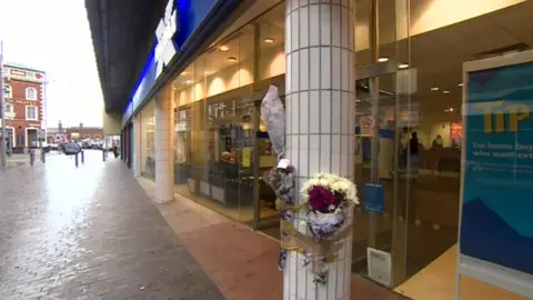 BBC Flowers taped to a pillar in front of Halifax Bank