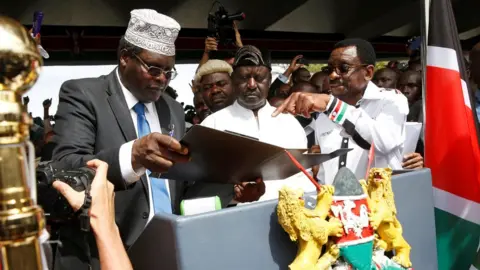 Reuters Kenyan opposition leader Raila Odinga of the National Super Alliance (NASA) is assisted by lawyer Miguna Miguna and James Orengo as he takes a symbolic presidential oath of office in front of his supporters in Nairobi, Kenya January 30, 2018.