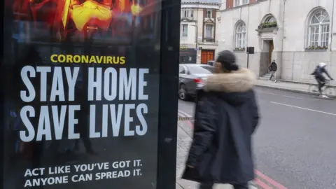 Richard Baker / Getty Images A UK government sign on a bus stop asks people to stay at home