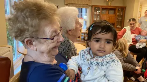 BBC Patricia holding a child