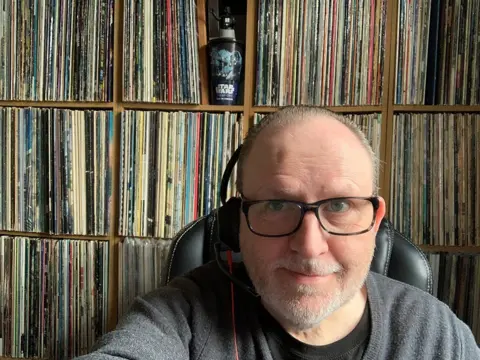 Phil Caldwell Man with albums behind him