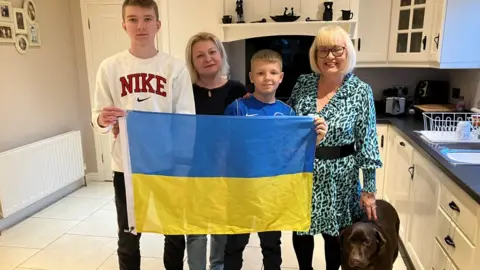 Diamid, Kristina, Makar and Una holding a Ukraine flag