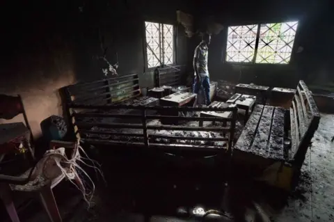 Getty Images A man walks in a burnt out restaurant in 2019 that was destroyed in fighting between armed Anglophone separatists and the Cameroonian military.