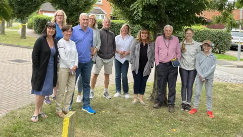 Eleven residents of Fallowfields in Crick standing in front of trees