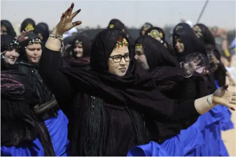 Getty Images Sahrawi women wearing black headscarves with what appears to be blue wrappers.